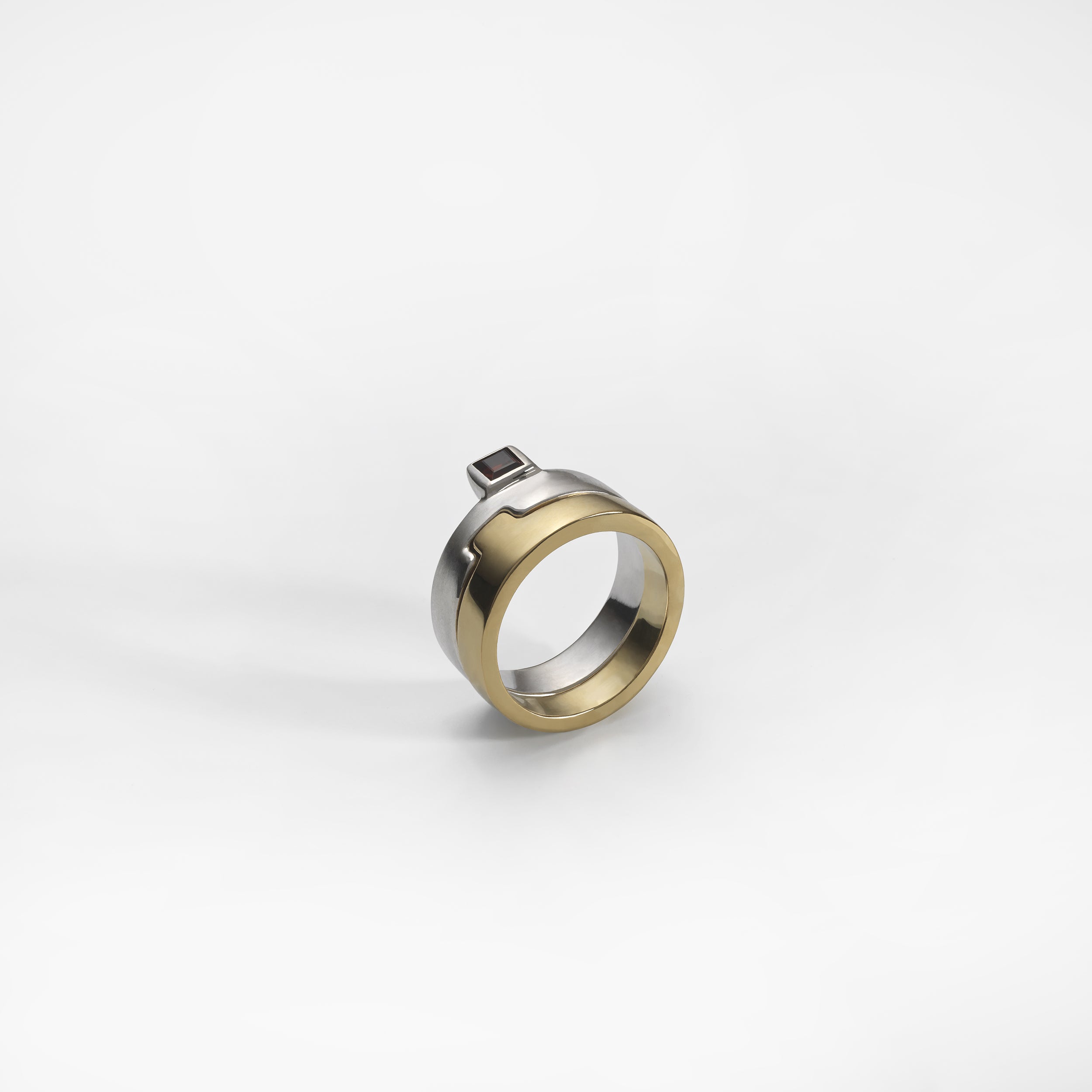 Puzzle Bicolor ring, sterling silver and yellow gold plated, set with a red garnet