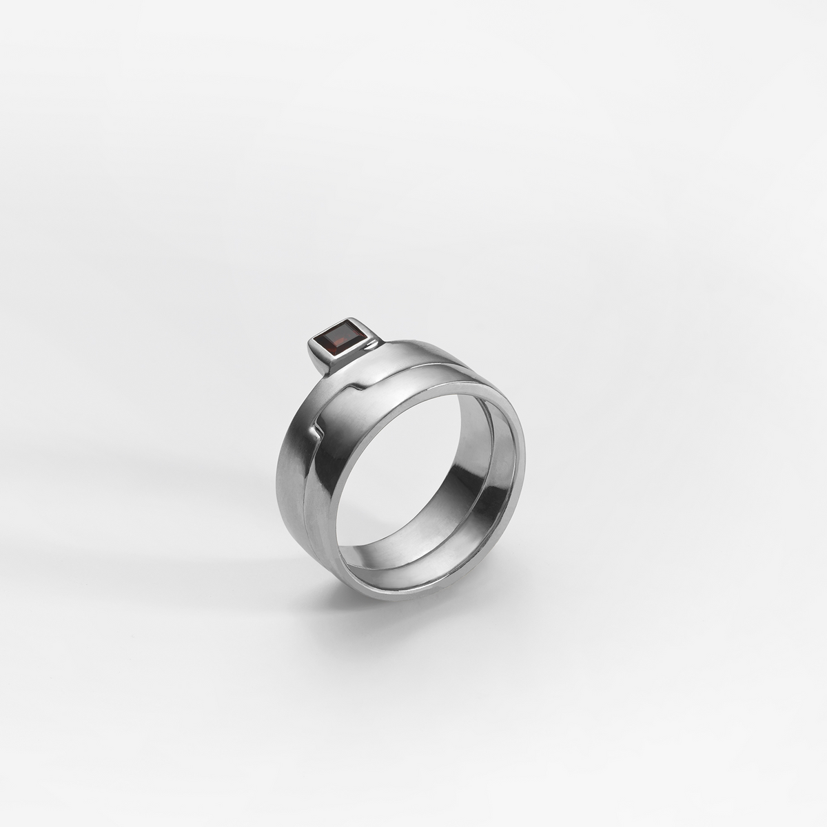 Puzzle ring, sterling silver, set with a red garnet